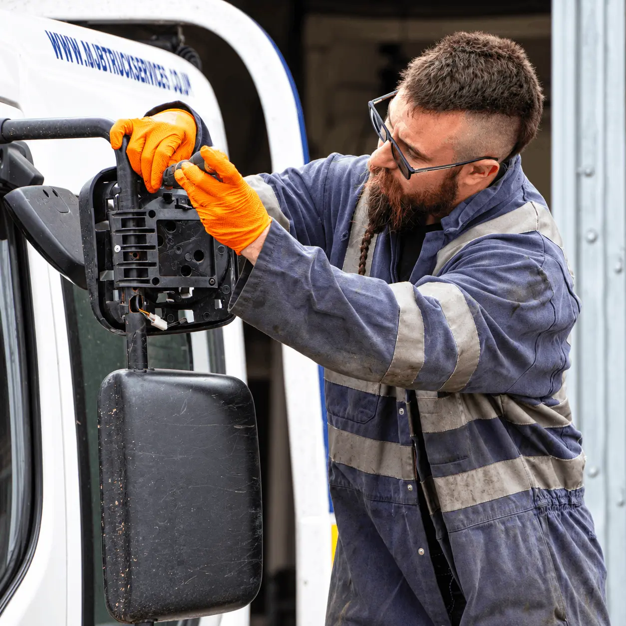 Mechanic-repairing-a-truck-mirror